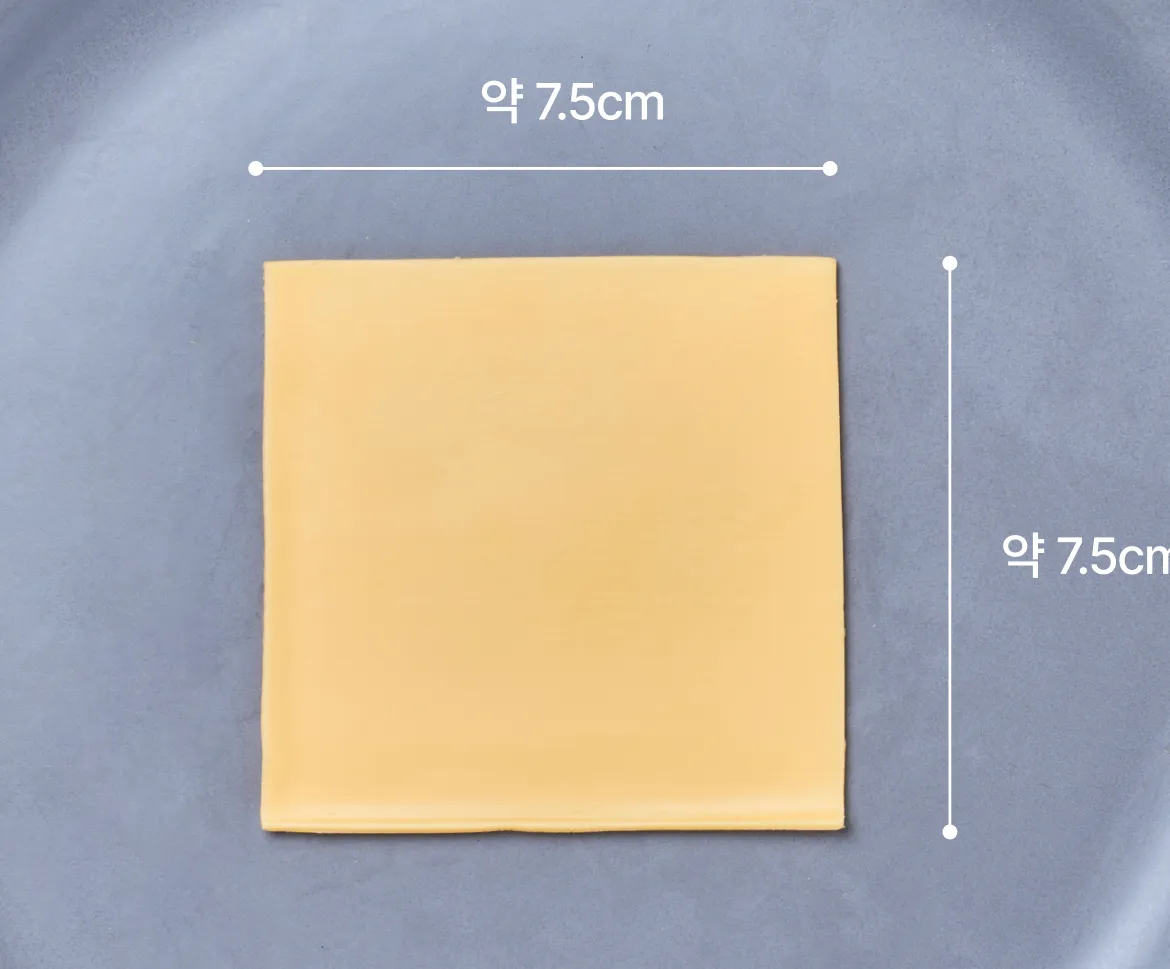 그레이 원형 접시 중앙에 놓인 앵커 체다치즈 슬라이스 1장의 실측 크기가 가로 7.5cm, 세로 7.5cm임을 안내하는 그래픽 이미지