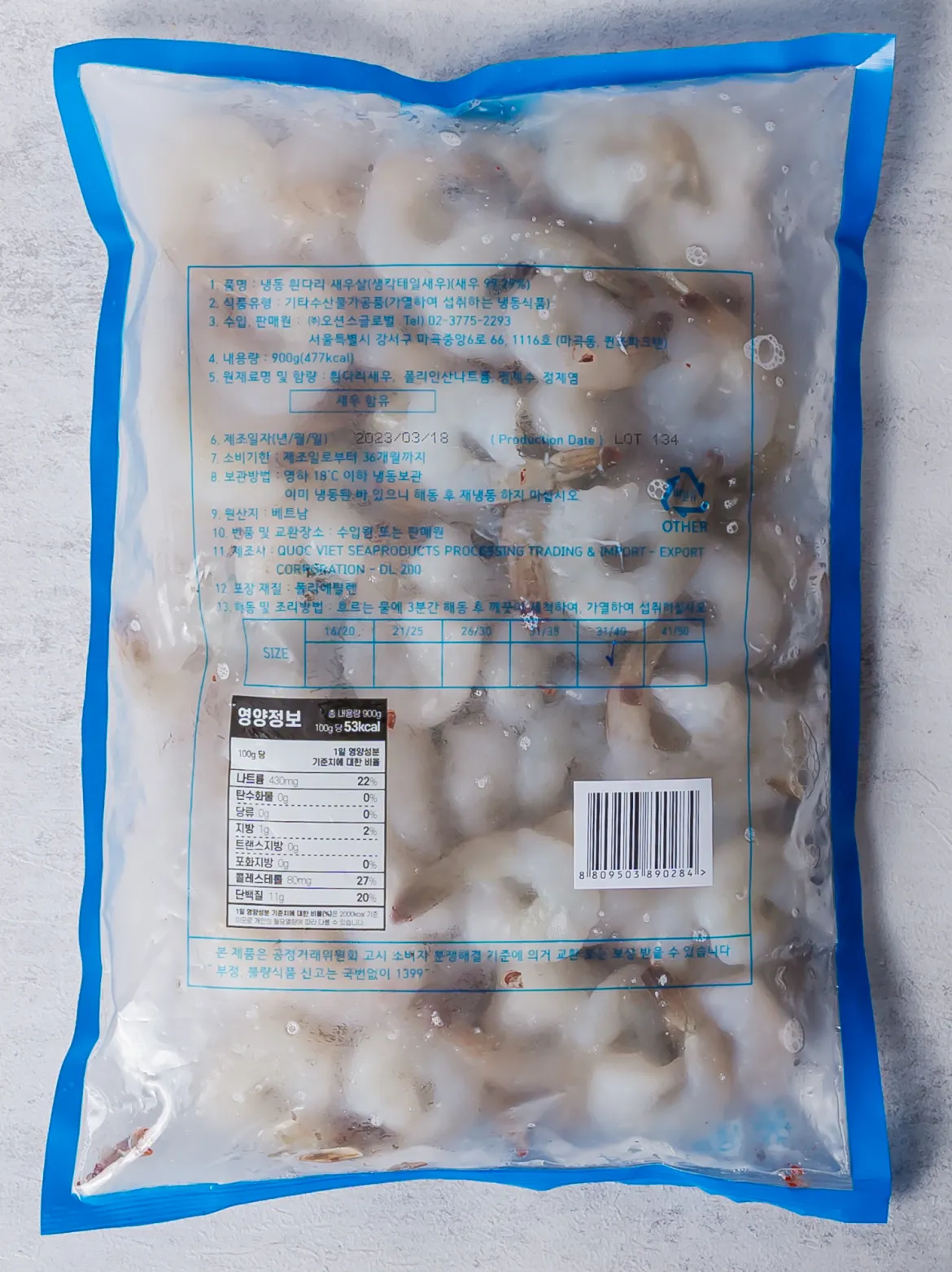 생칵테일 새우 900g 후면 백라벨 한글표시사항 이미지. 식품의 유형 수산물가공품(가열하여 섭취하는 냉동식품), 원산지 수입산, 총 내용량 900g, 영하 18도 이하 냉동 보관법, 해동 후 재냉동 금지 주의사항 및 핵심 원재료 스펙 정보가 포함된 고시 문구.